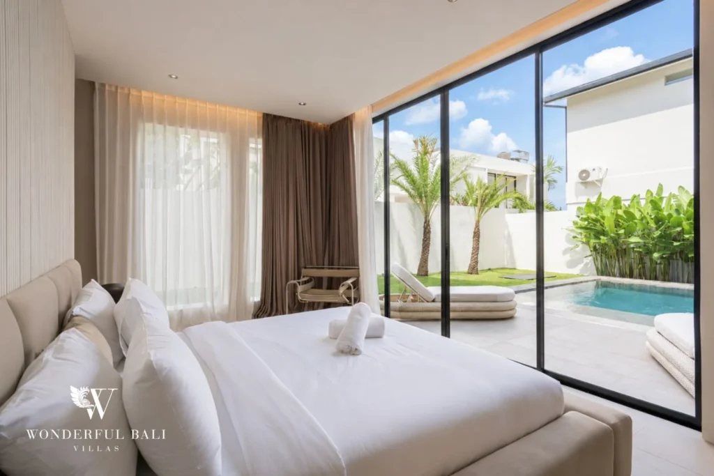 En-suite bedroom with full-height glass and pool view at a modern villa in Umalas, Bali