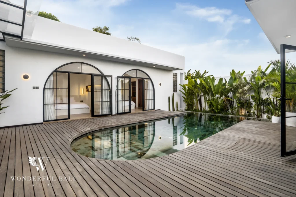 Timber pool deck and arched-window facade at a 3-bedroom villa in Pererenan, Bali