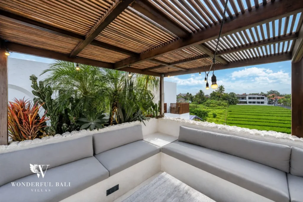 Rooftop lounge under a timber pergola looking over rice fields at a 4-bedroom villa in Canggu Bali