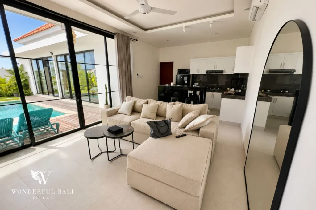 Open-plan living and kitchen with full-height glass to the pool in a 2-bedroom villa in Seseh Bali