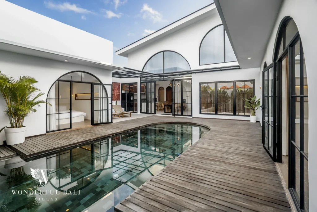 Central pool courtyard with double-height arched windows at a 3-bedroom villa in Pererenan, Bali