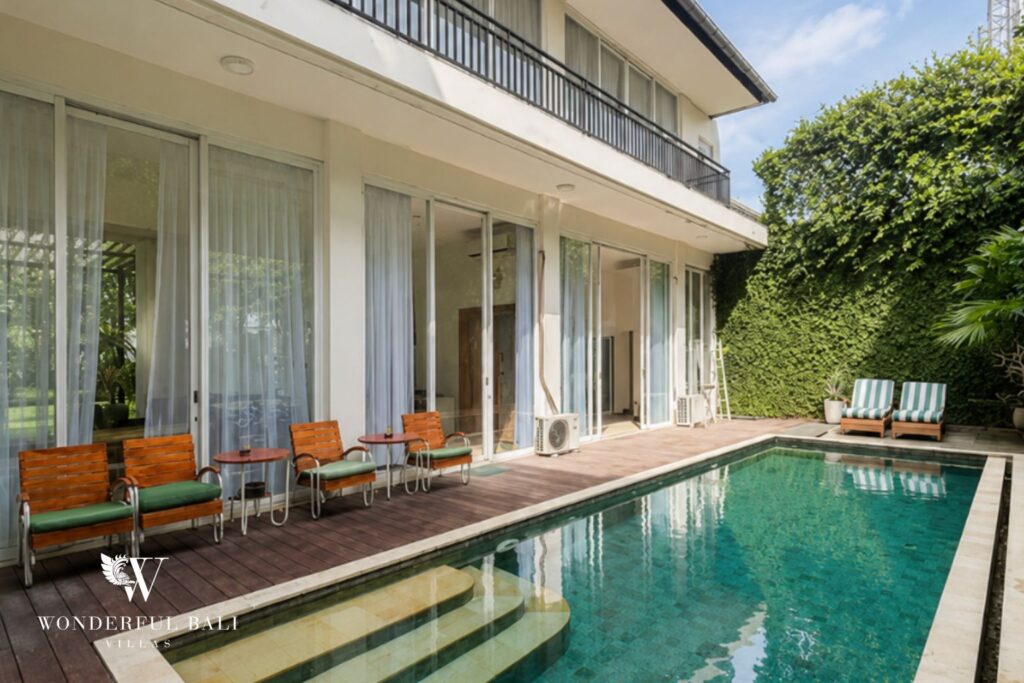 Private pool beside the double-storey villa facade at a villa in Seminyak
