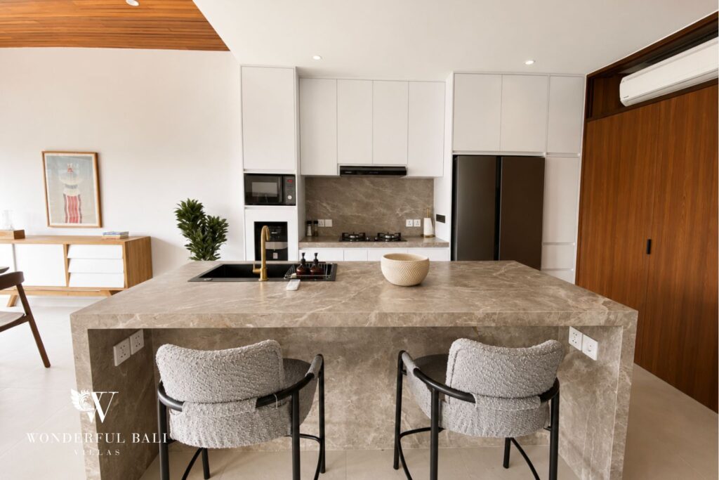 Kitchen island with bar stools and cabinetry at a villa in Berawa, Canggu