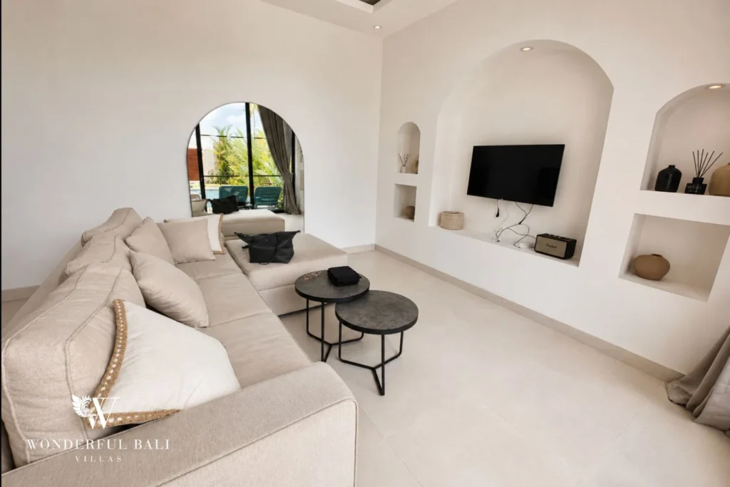 L-shaped sofa and arched TV niche in the living room of a 2-bedroom villa in Seseh Bali