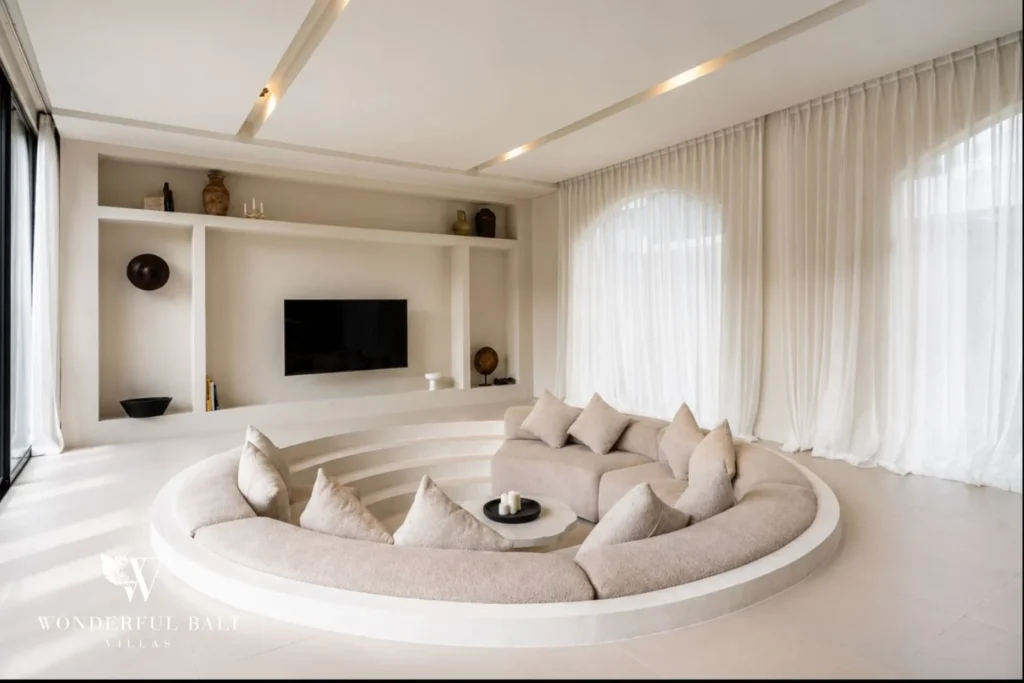 Curved sunken living room with sheer curtains and built-in TV niche at a villa in Umalas, Bali