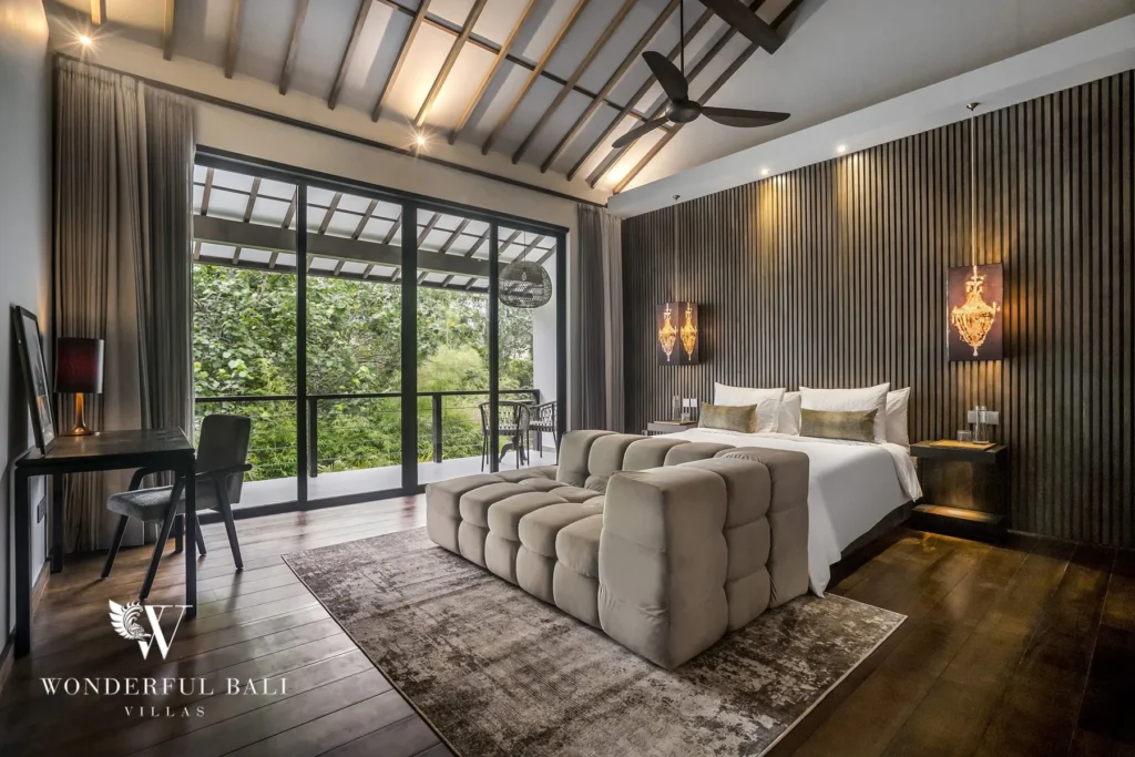 Bedroom with a king bed, work desk, TV and glass doors opening to a balcony over greenery at a 2-bedroom villa in Pererenan, Bali