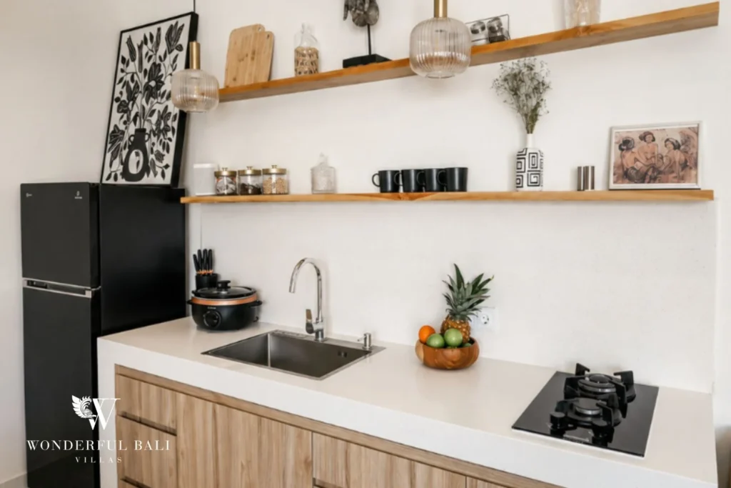 Kitchen with white stone counter teak cabinetry and open shelving in a 2-bedroom villa in Cemagi Bali