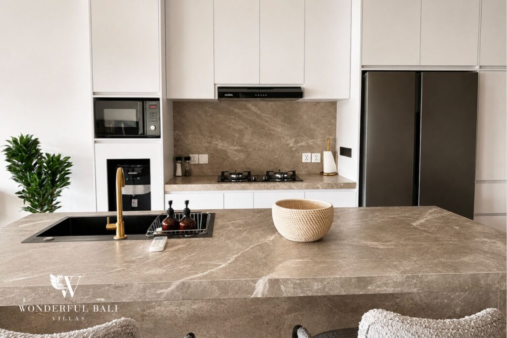 Kitchen with stone countertop and dark cabinetry at a villa in Berawa, Canggu