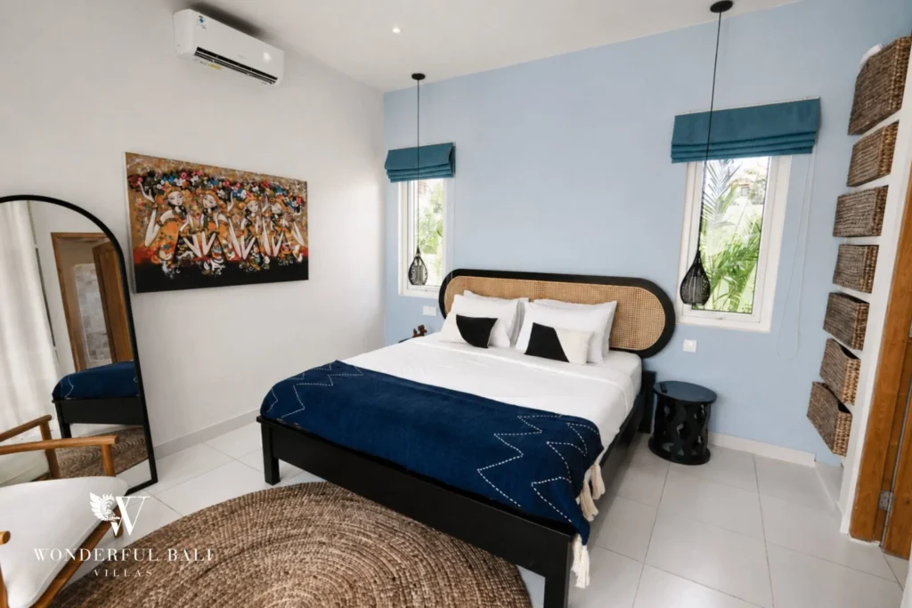 Bedroom with rattan headboard and pale blue wall in a 2-bedroom villa in Cemagi Bali