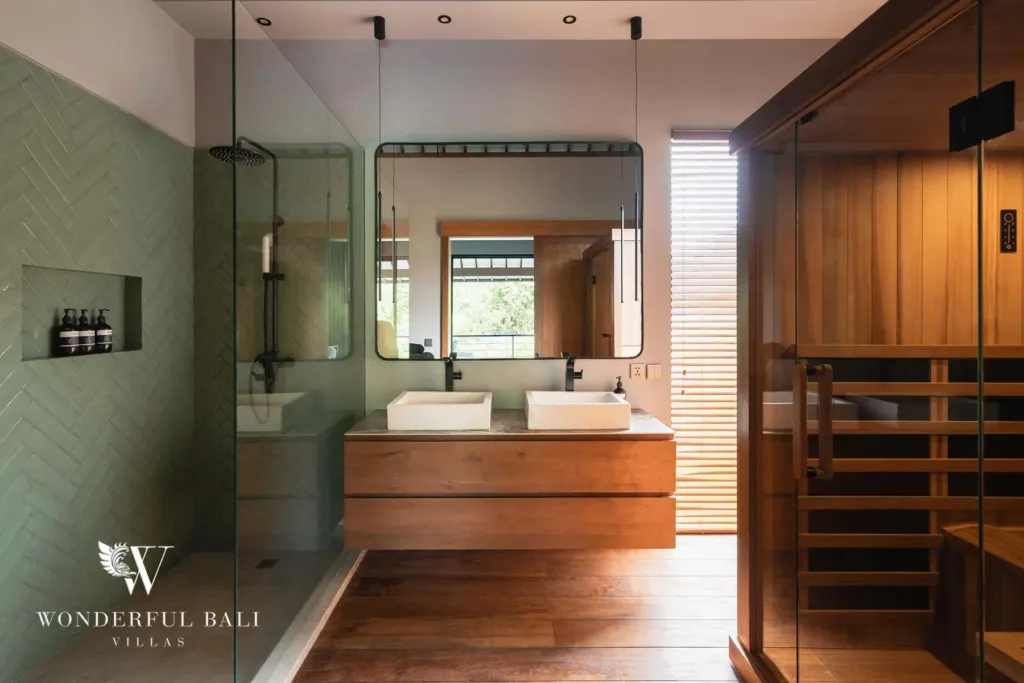 2BR villa for rent in Pererenan — bathroom, a bright bathroom with green subway tiles, a glass walk-in shower, twin stone basins on a timber vanity and a mirror by the sauna at a 2-bedroom villa