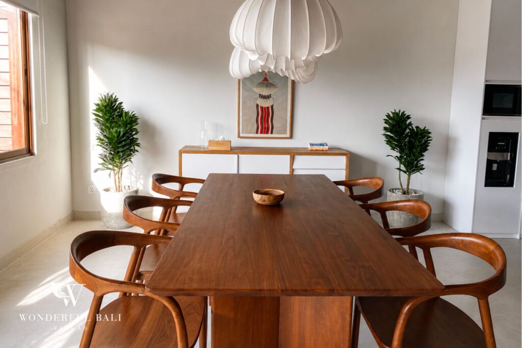 Round timber dining table with six seats at a villa in Berawa, Canggu