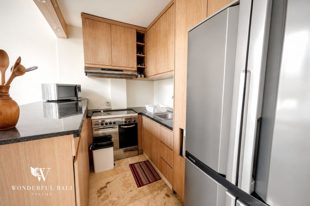 Fully equipped kitchen with timber cabinetry at a villa in Seminyak
