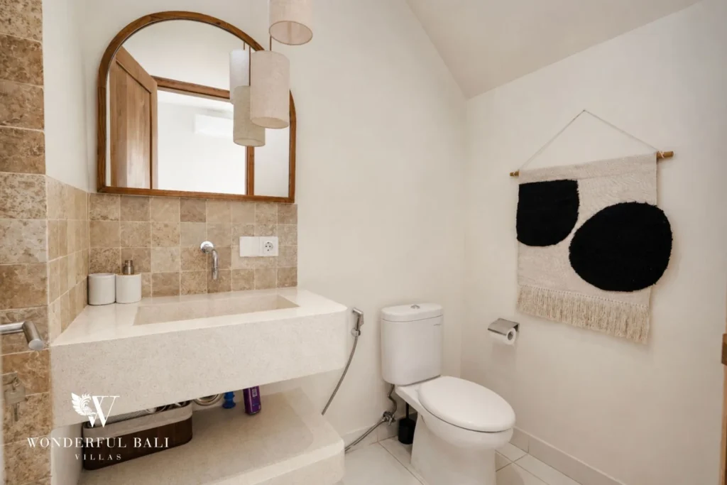 Bathroom with travertine tile and terrazzo trough basin in a 2-bedroom villa in Cemagi Bali