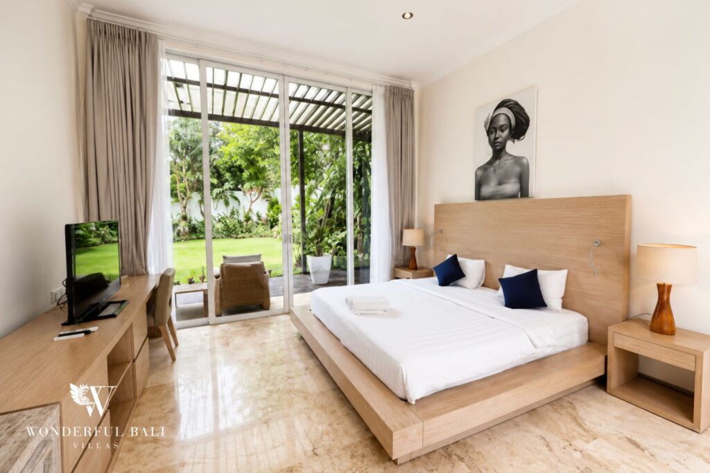 Bedroom with king bed and garden view at a villa in Seminyak