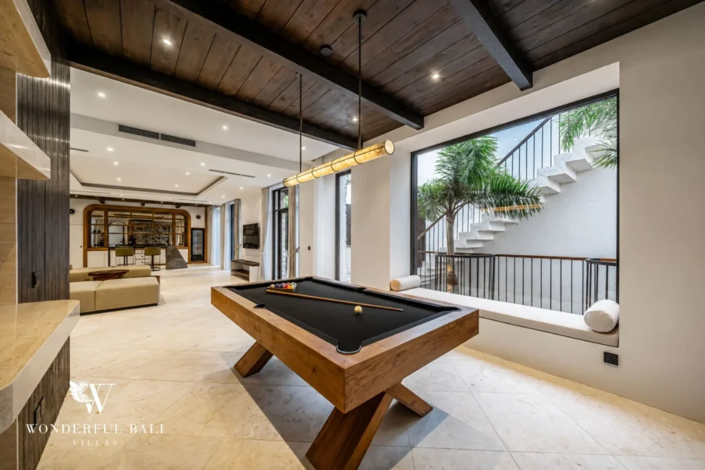 Games room with a teak pool table under a dark timber ceiling in a 4-bedroom villa in Canggu Bali