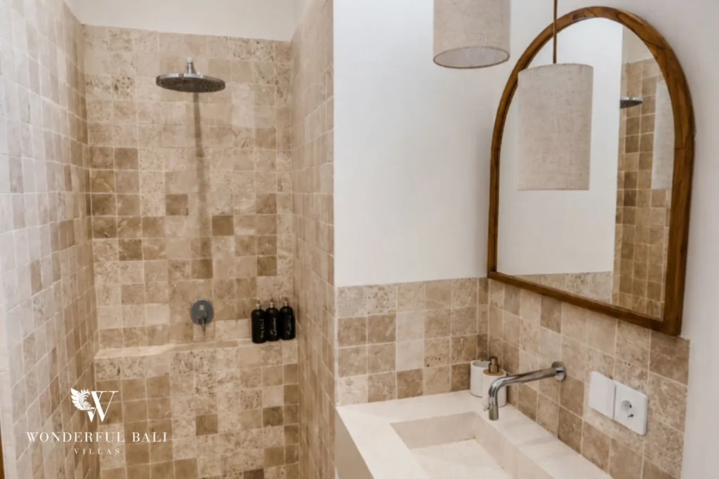 Walk-in rain shower in travertine mosaic tile at a 2-bedroom villa in Cemagi Bali
