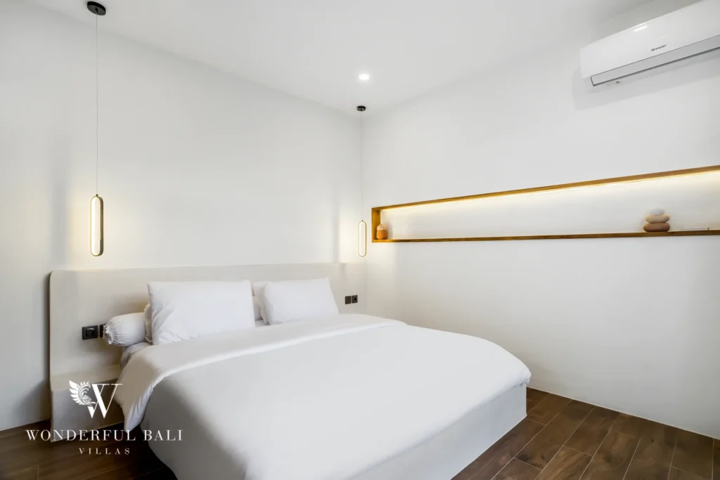 Minimalist bedroom with lit timber shelf at a 3-bedroom villa in Pererenan, Bali