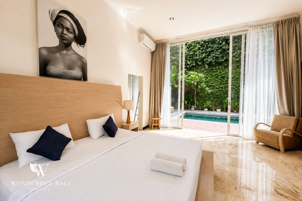 Bedroom with king bed and pool access at a villa in Seminyak