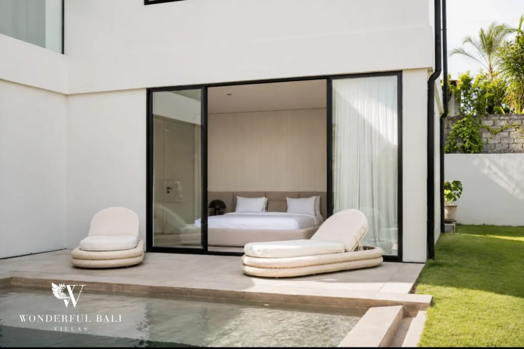 Poolside terrace and ground-floor bedroom with sliding glass doors at a villa in Umalas, Bali