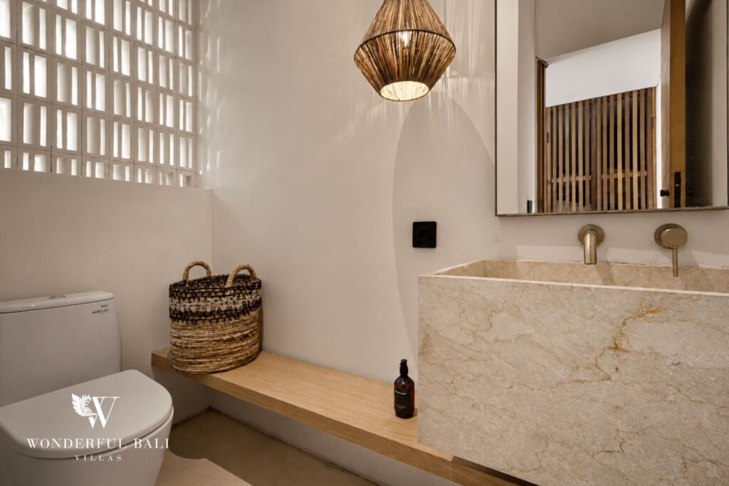 En-suite bathroom with round mirror and vanity at a villa in Petitenget, Seminyak