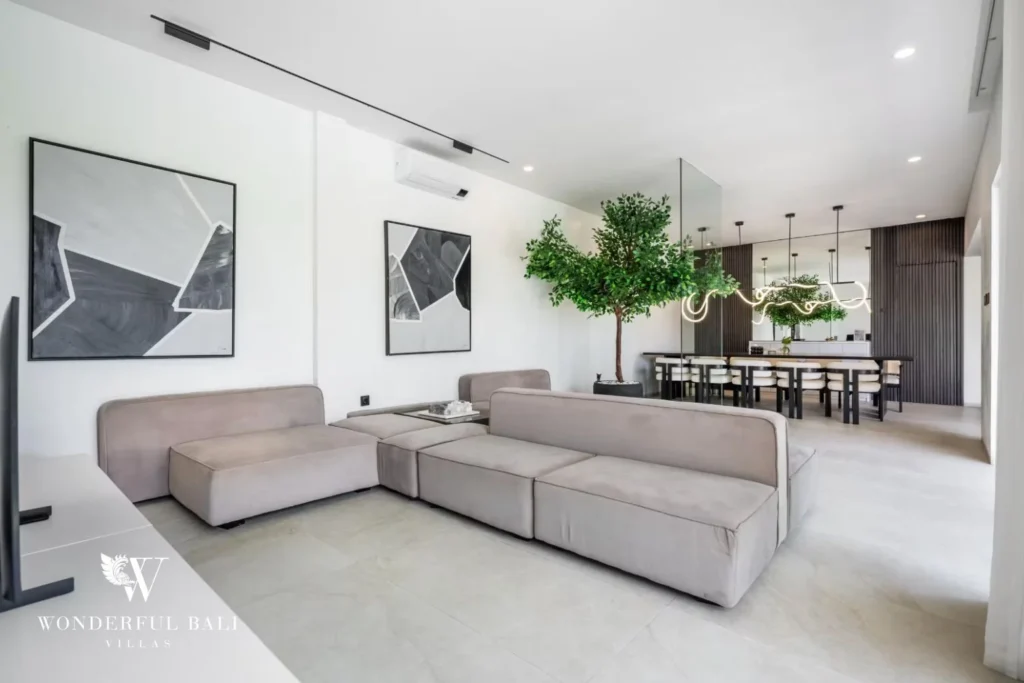 Wide living room view showing the sofa, framed art and the dining table beyond at a 5-bedroom villa in Pererenan, Bali