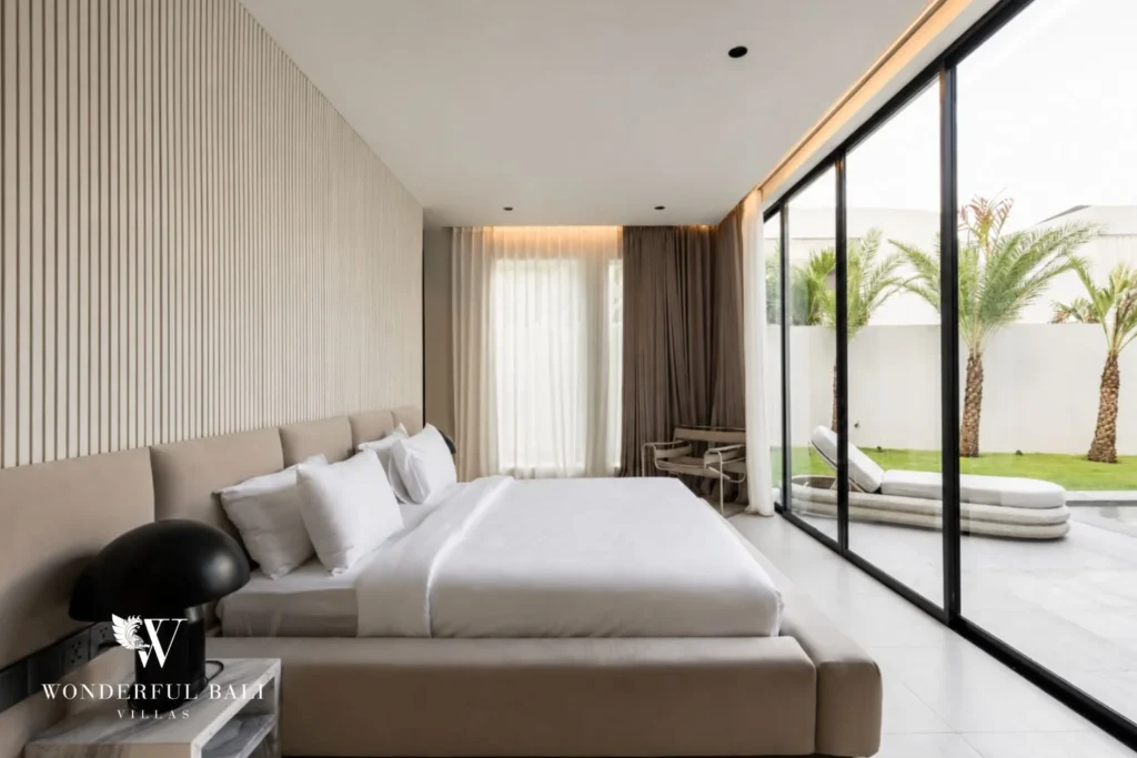Master bedroom with slatted headboard and garden view at a modern villa in Umalas, Bali