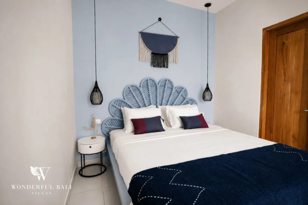 Second bedroom with painted bed frame and woven wall hanging in a 2-bedroom villa in Cemagi Bali