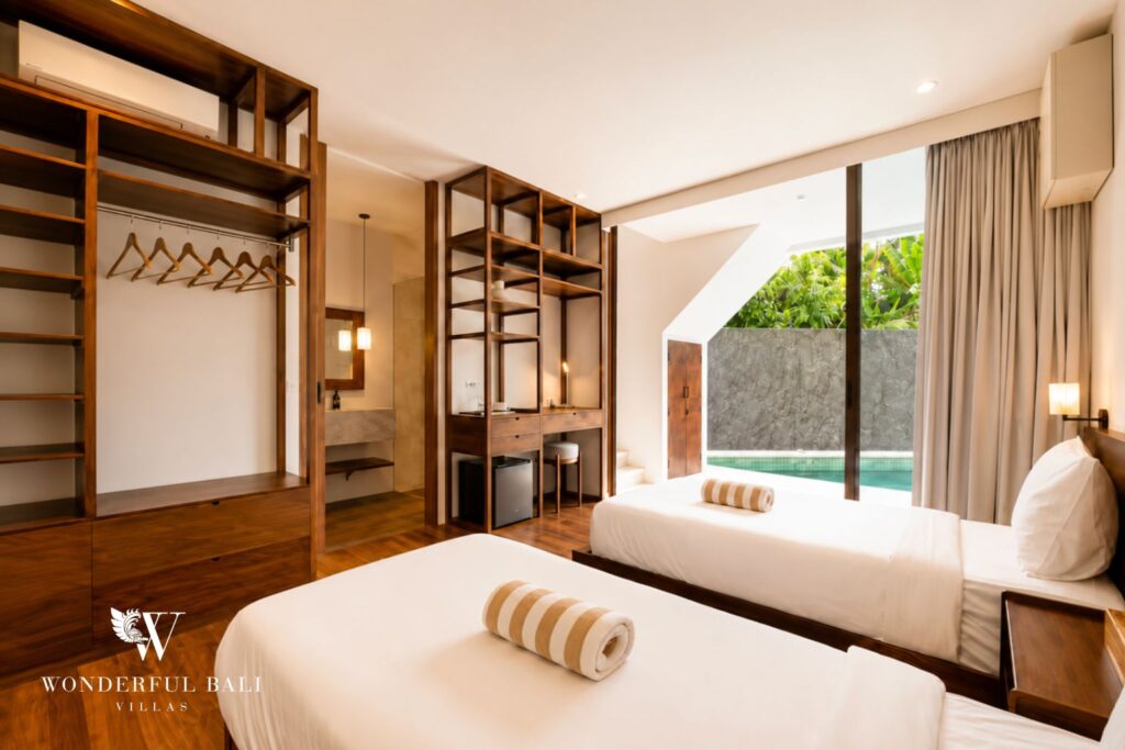 Twin bedroom with garden view and full-height glazing at a villa in Berawa, Canggu