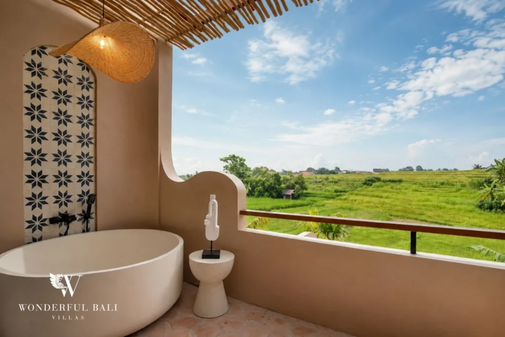 A freestanding terrace bathtub under a woven light with sweeping rice-field views at a 3-bedroom villa in Pererenan, Bali