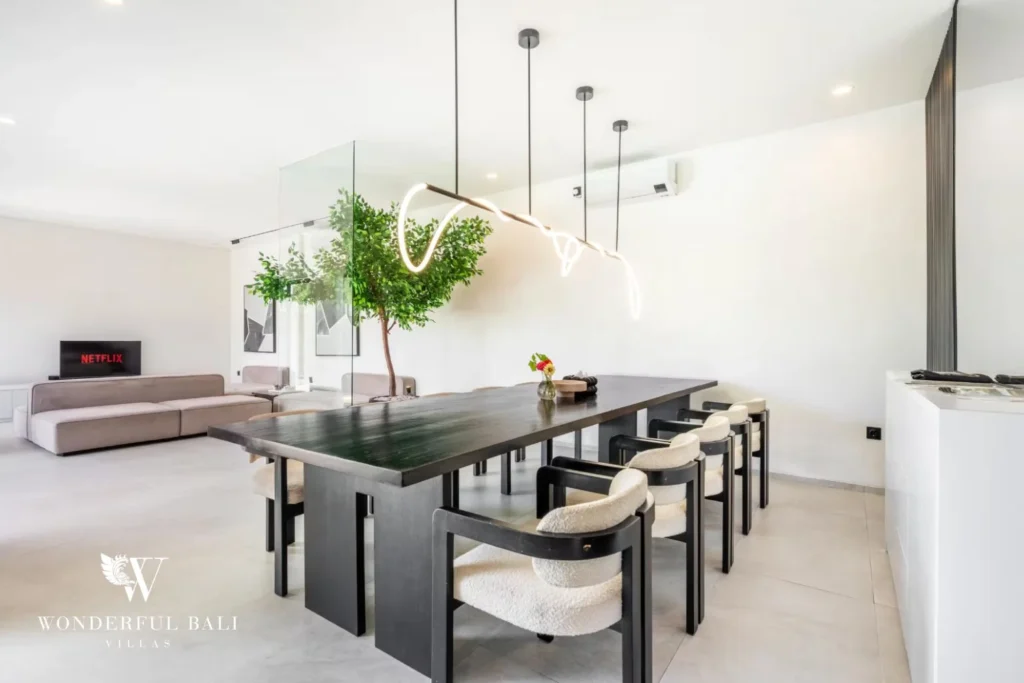 Dining table with boucle chairs opening onto the living area and TV lounge at a 5-bedroom villa in Pererenan, Bali