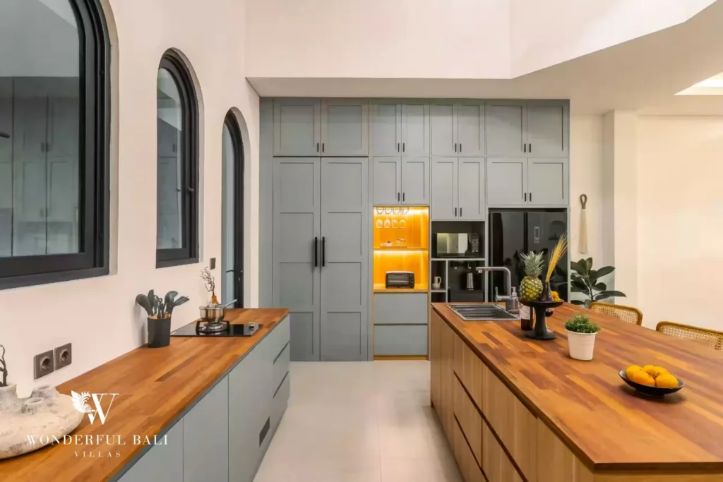 A second fully equipped kitchen with grey cabinetry, a timber island and floor-to-ceiling storage at a 4-bedroom villa in Pererenan, Bali