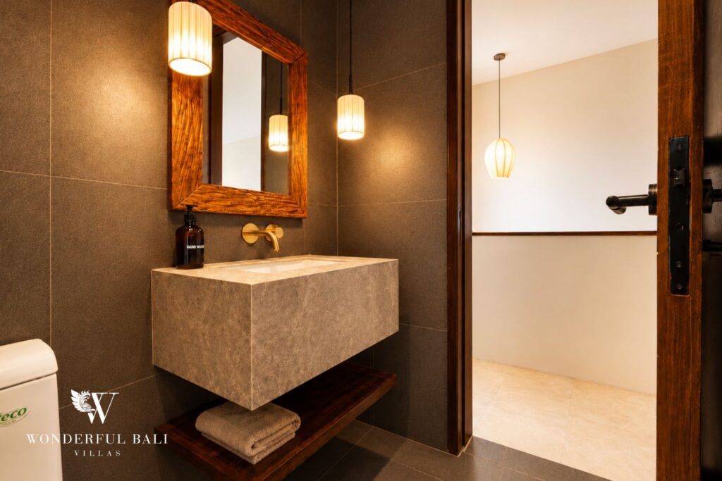 En-suite bathroom with stone vanity and mirror at a villa in Berawa, Canggu
