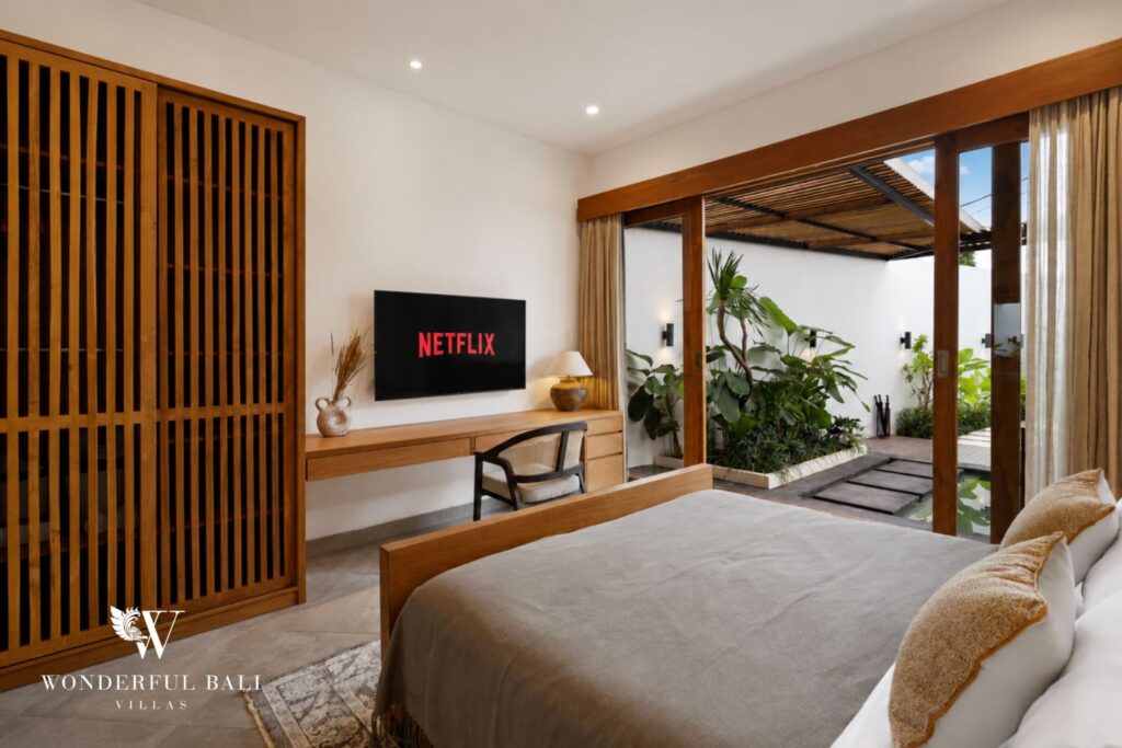 En-suite king bedroom with pool view and smart TV at a villa in Canggu