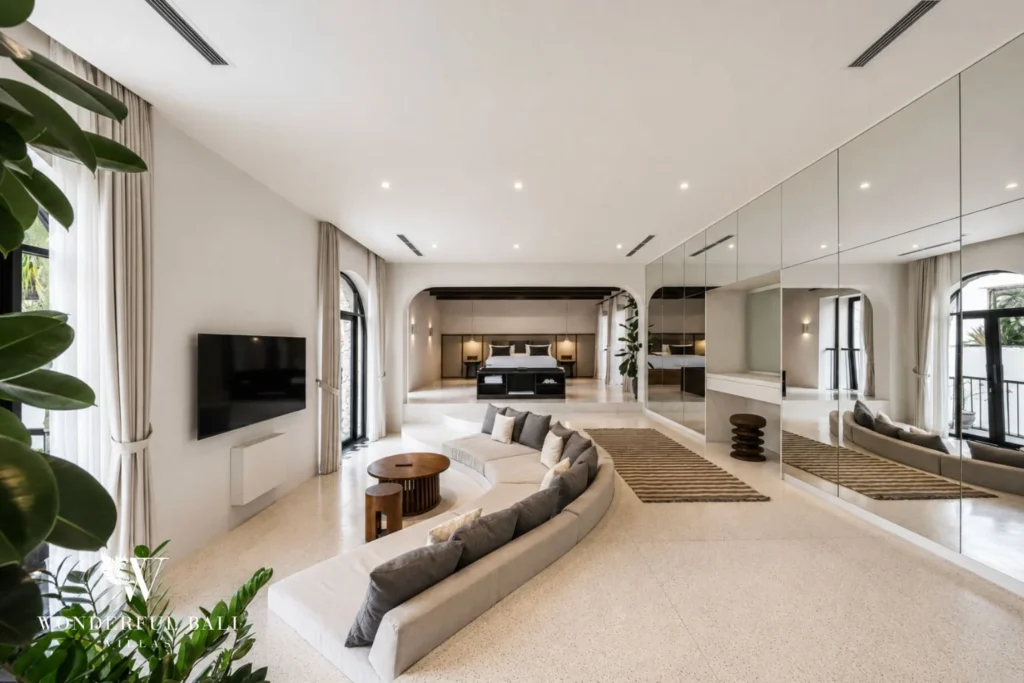 Master suite with terrazzo floor curved sofa and mirrored dressing wall in a 4-bedroom villa in Canggu Bali