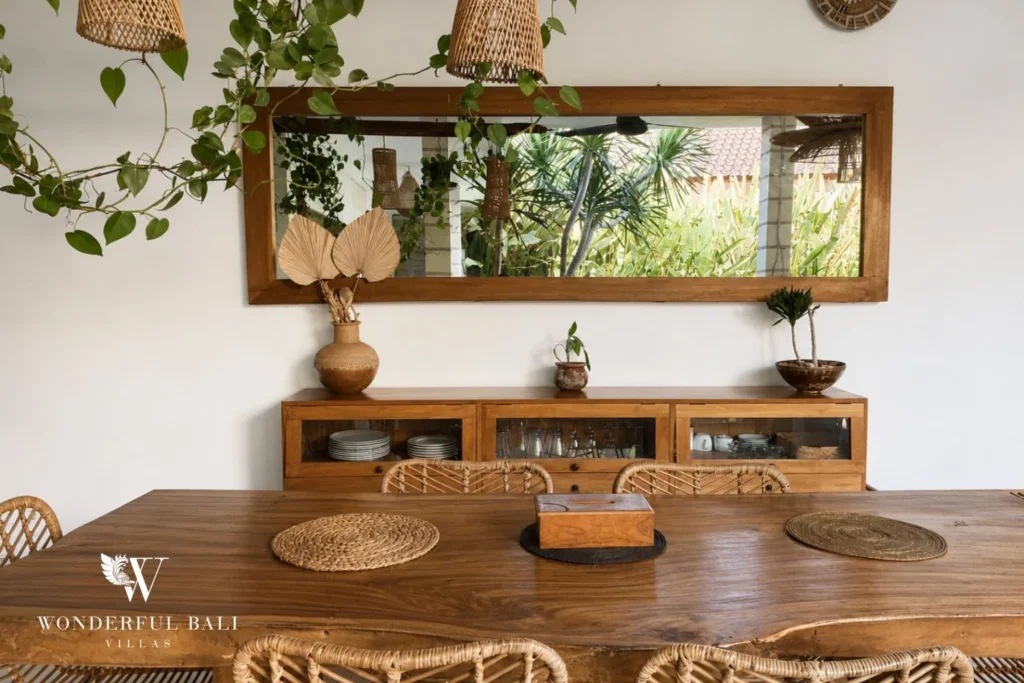 Dining table with carved timber mirror and rattan settings at a villa in Batu Bolong, Canggu