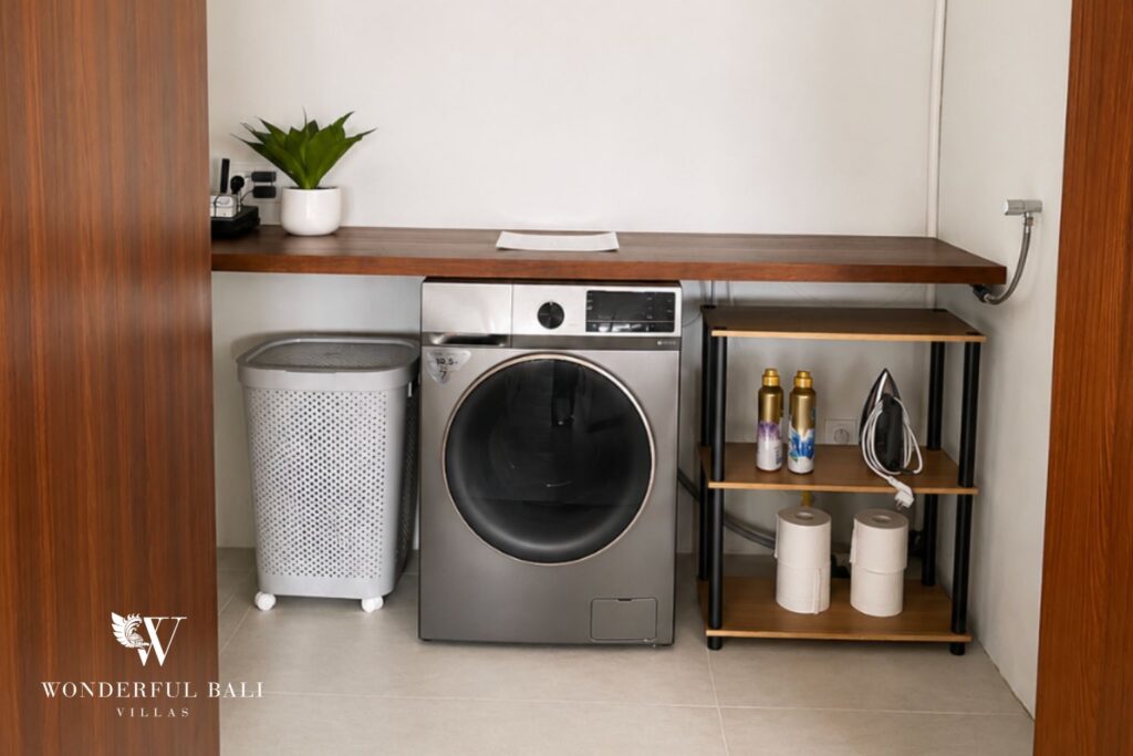 Laundry room with washer-dryer and shelving storage at a villa in Berawa, Canggu
