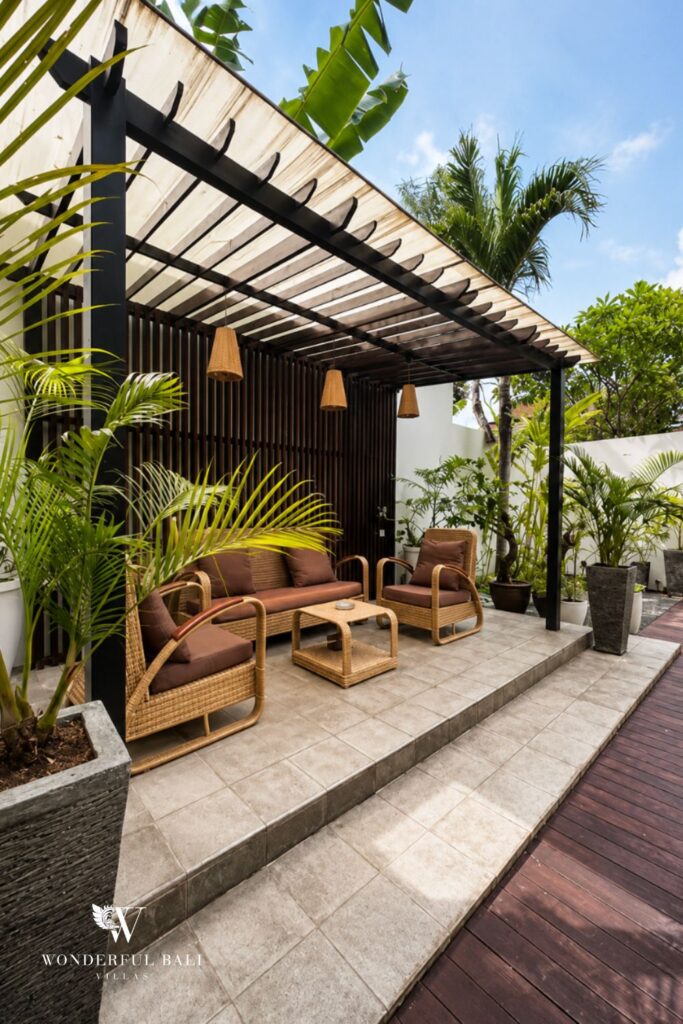 Outdoor lounge under a pergola beside the garden at a villa in Seminyak
