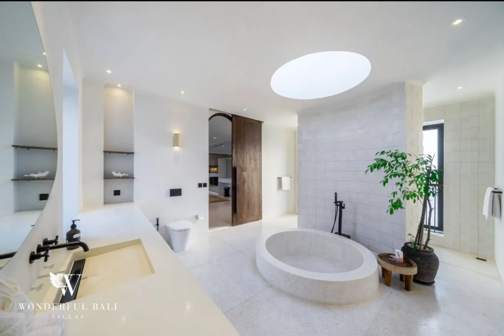 Master bathroom with terrazzo tub stone tiling and timber barn door in a 4-bedroom villa in Canggu Bali