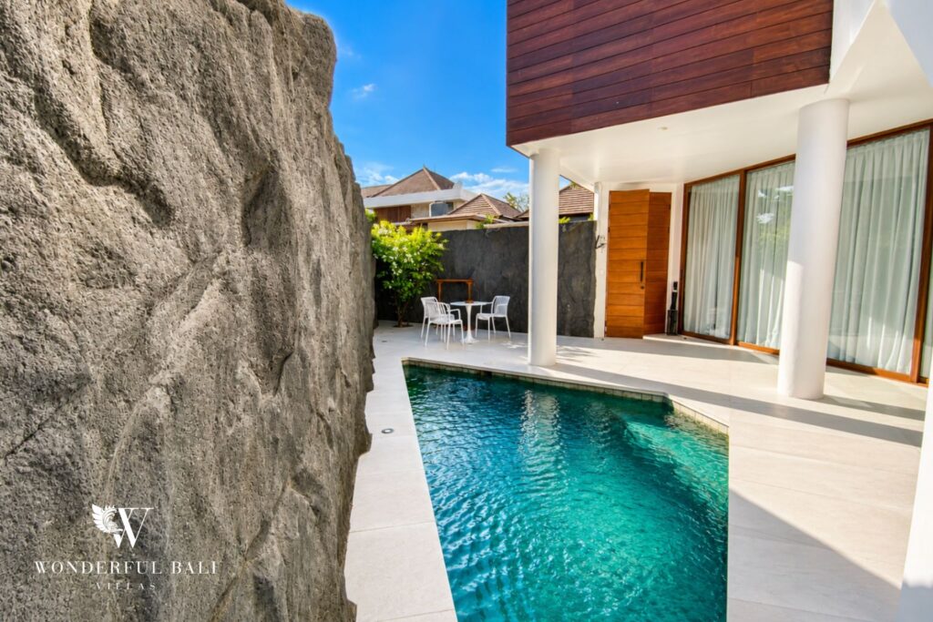 Private pool beside a natural stone feature wall at a villa in Berawa, Canggu