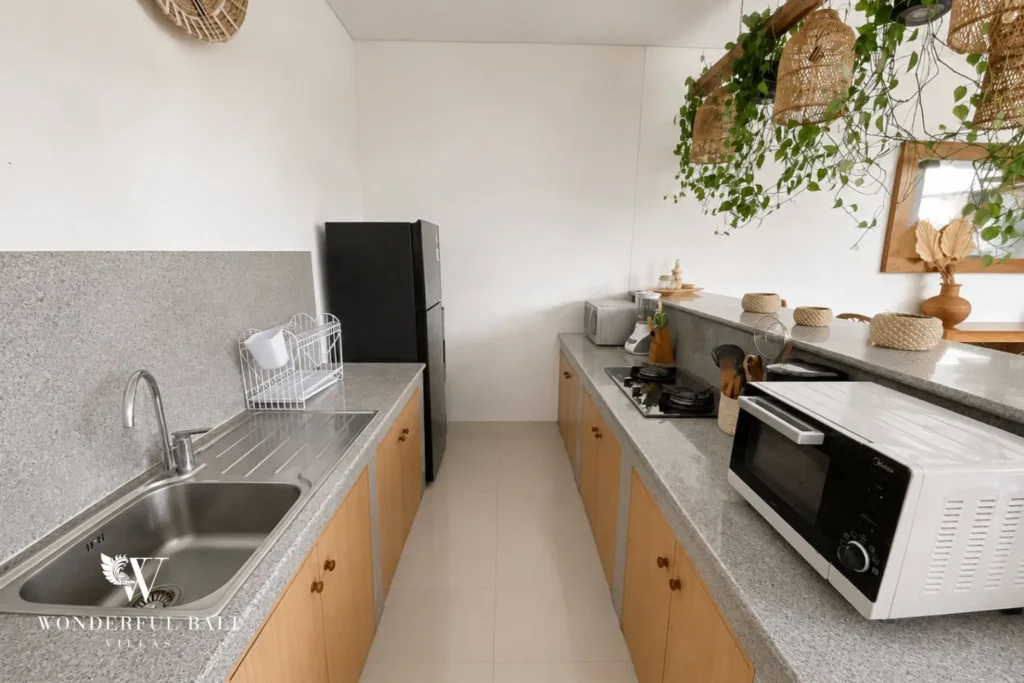 Galley kitchen with oven and stainless sink at a villa in Batu Bolong, Canggu