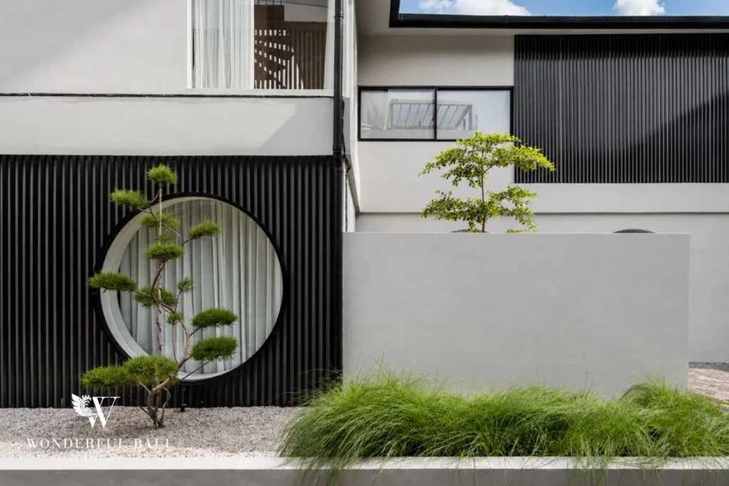 Architectural detail with round moon window, bonsai and black timber battens at a villa in Umalas, Bali