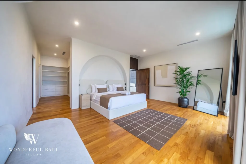 Bedroom with arched headboard alcove and walk-in closet in a 4-bedroom villa in Canggu Bali