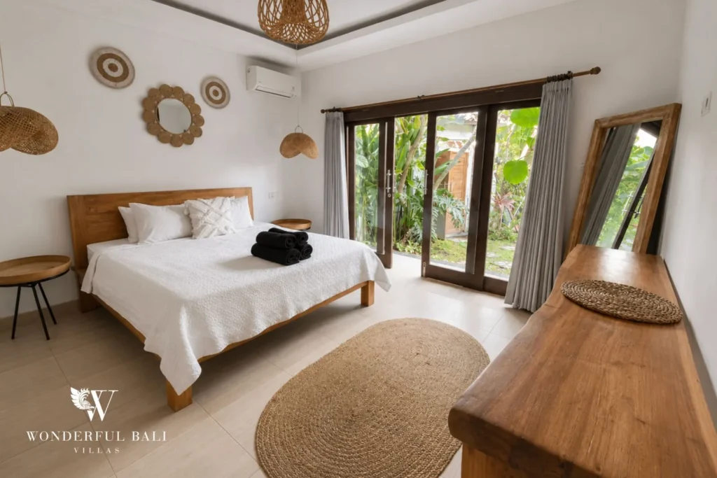 Boho bedroom with pool view and folding doors at a villa in Batu Bolong, Canggu