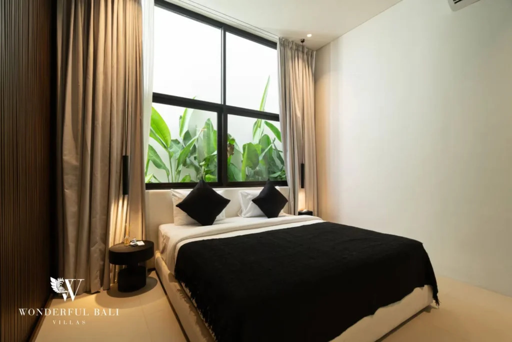 3BR ocean-view villa in Seseh — bedroom with black bed and garden view