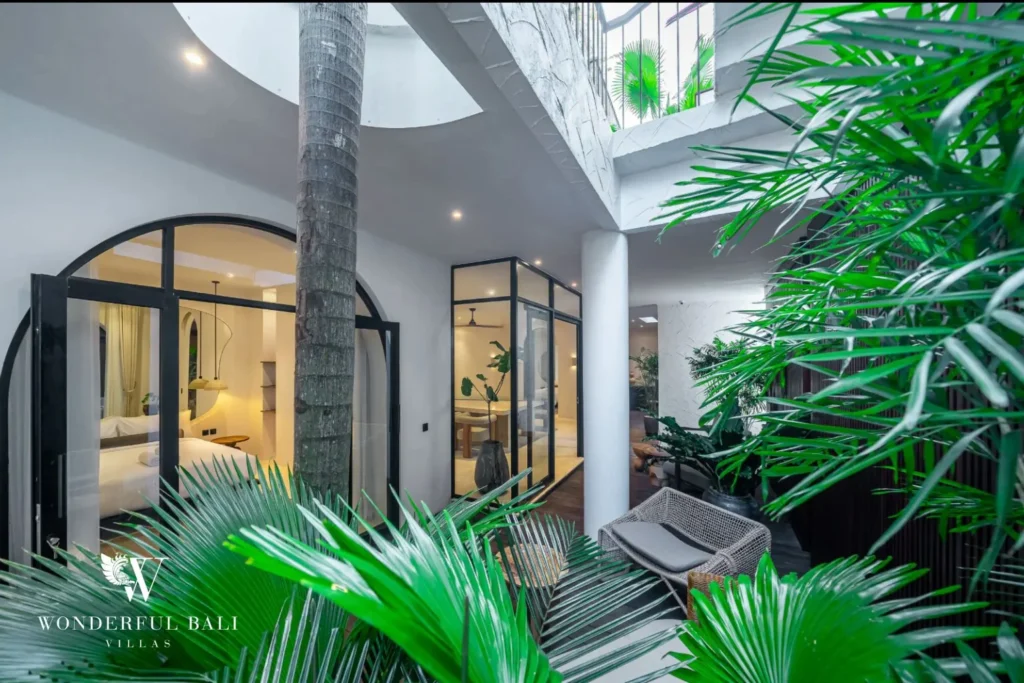Internal courtyard with a palm growing through the deck in a 4-bedroom villa in Canggu Bali