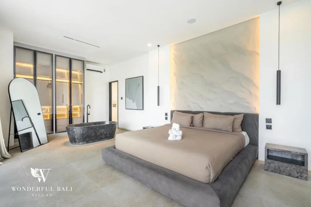 Main suite bedroom showing the king bed, walk-in wardrobe and freestanding stone tub at a 5-bedroom villa in Pererenan, Bali