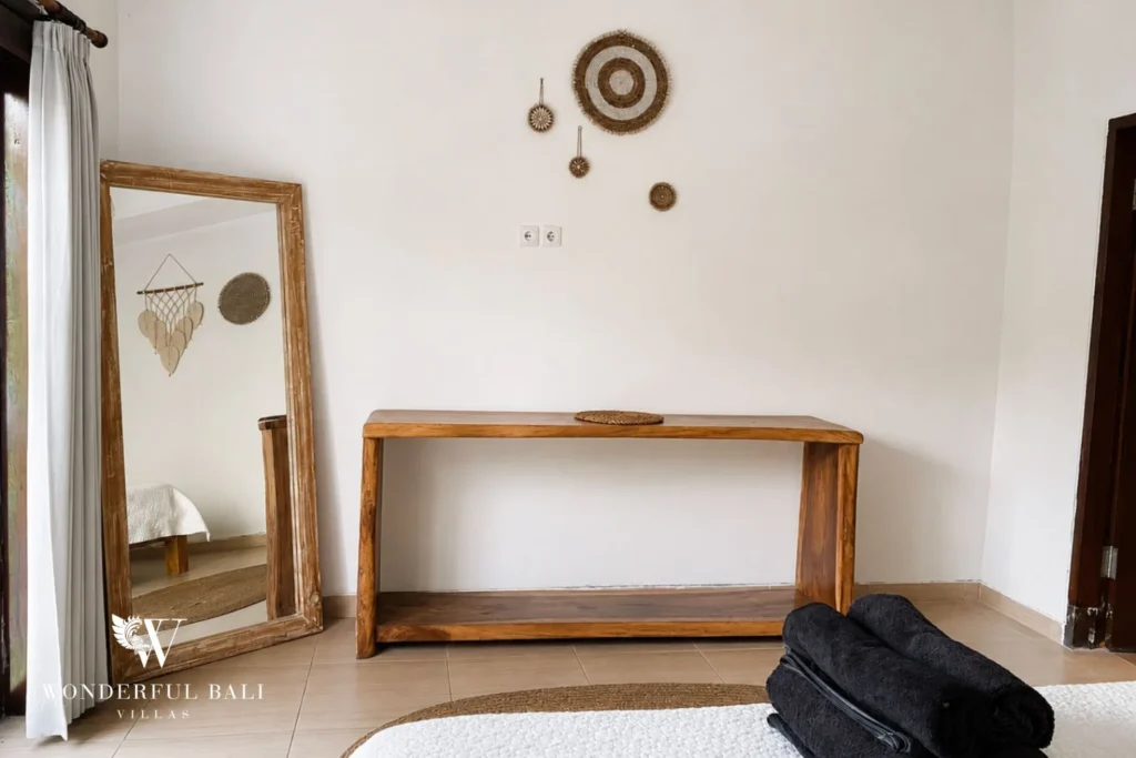 Bedroom with timber console and full-length mirror at a villa in Batu Bolong, Canggu