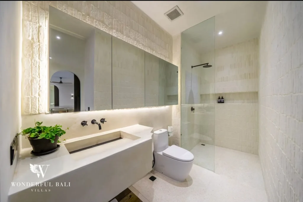 Bathroom in limewashed tile with a glass walk-in shower in a 4-bedroom villa in Canggu Bali