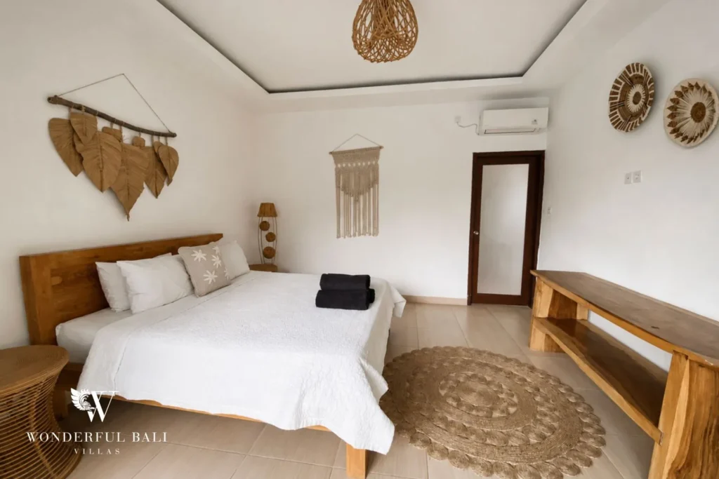 Boho bedroom with garden door and woven wall art at a villa in Batu Bolong, Canggu