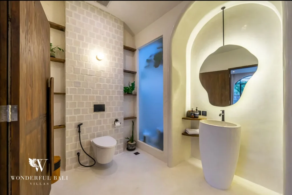 Bathroom with sculpted pedestal basin and brick tile wall in a 4-bedroom villa in Canggu Bali